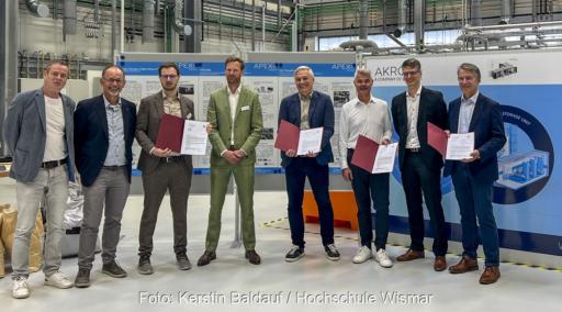 Wissenschaftler stehen aufgereiht mit Minister im LIKAT, sie erforschen den Wasserstofftransport mit Formiatsalz.