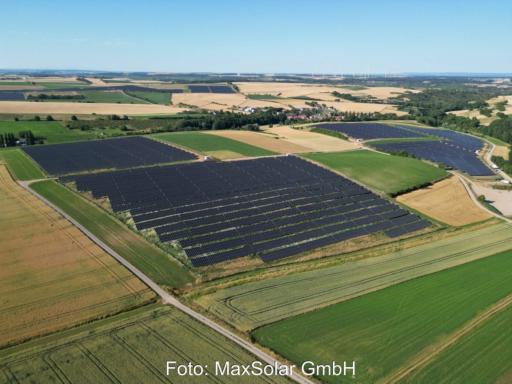 Solarpark aus der Vogelperspektive zwischen landwirtschaftlichen Flächen gelegen.