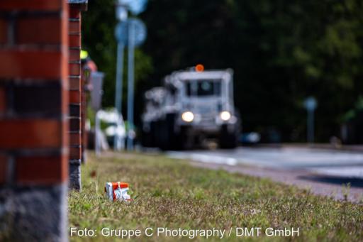 In der Ferne kommen unscharf Vibro Trucks eine Straße entlang gefahren.