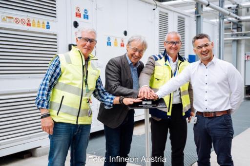 Vier Personen drücken symbolisch für die Inbetriebnahme auf einen Knopf. Die Hände liegen übereinander.