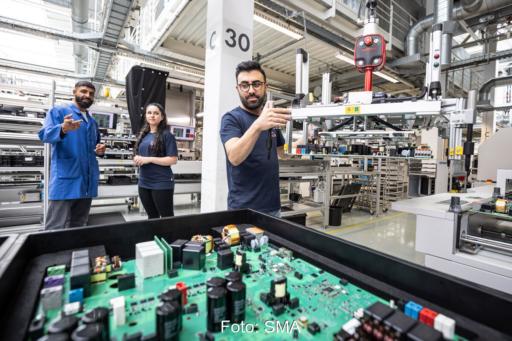 Fertigung von Photovoltaik-Wechselrichtern bei SMA in Kassel. Die Hauptplatine von einem Wechselrichter mit zahlreichen elektronischen Bauteilen ist offen sichtbar.