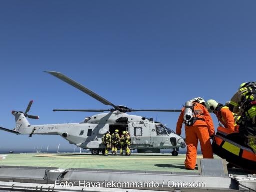 Einsatzkräfte steigen in einen Hubschrauber NH90.