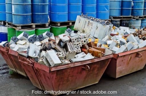Abfallsammelcontainer, in dem sich alte Batterien stapeln.