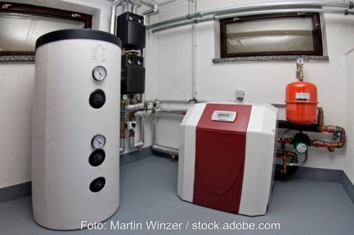 Wärmepumpe neben einemPufferspeicher im Heizungskeller - Symbolbild für das GEG Gebäudeenergiegesetz
