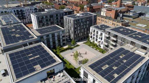 Hochhäuser in der Stadt mit PV-Anlagen auf den Dächern.