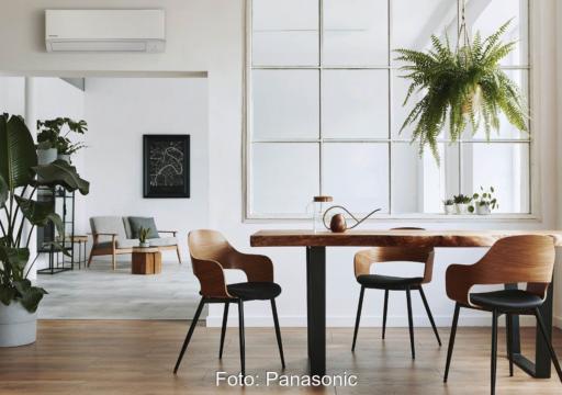 Offener Wohnraum mit Pflanzen und einem Klimagerät über einem Durchbruch.