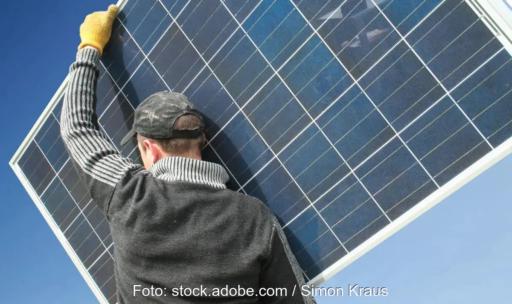 Ein Mann trägt ein Photovoltaik-Modul, Enerix bietet den Schutzbrief Protect für Photovoltaik- und Wärmepumpeninstallationen an.