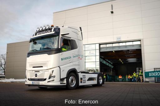 Enercons erster E-LKW für die Transportlogistik in Fahrt vor einer Gewerbehalle.