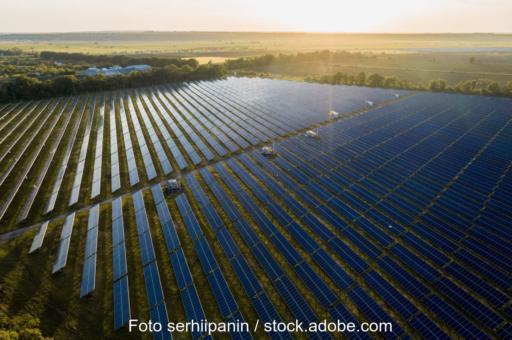 Großer Freiflächen-Solarpark bei tiefstehender Sonne.