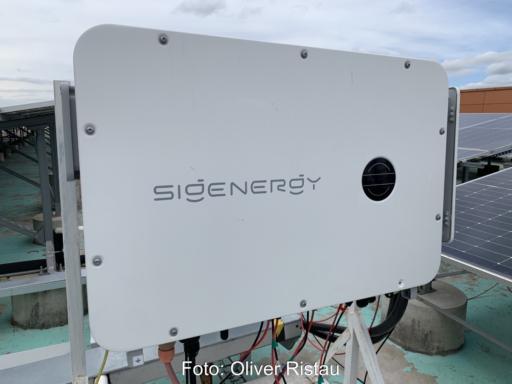 Wechselrichter von Sigenergy neben PV-Modulen.