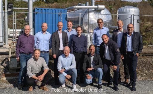 Menschen vor eine Energieanlage beim Kick-off-Treffen des Projektes Biovolatil, das kommunale Energiesysteme stärken will.