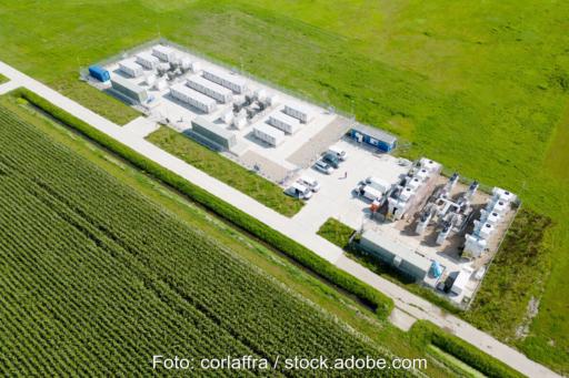 Luftbild zeigt einen großen Batteriespeicher mit mehreren Containern an einem Weg inmitten von Wiesen. Symbolbild für Flächenpooling.