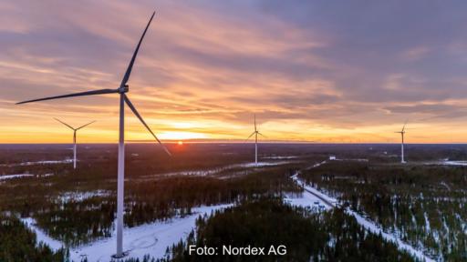 Nordex-Maschinen vom Typ Delta 4000 im schneebedeckten Flachland bei tiefstehender Wintersonne.