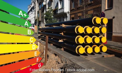 Kommunale Wärmeplanung: Ein Stapel neuer Rohre für Fernwärme an einer Baustelle, Grafik mit Energieeffizienzklassen für Gebäude nach dem GEG, Düsseldorf, Deutschland.