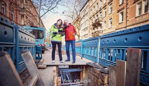 Zwei Menschen schauen in den Graben einer Wärmenetzbaustelle, Großwärmepumpen sollen in Wärmenetzen in Baden-Württemberg laut Netzwerk Großwärmepumpen vermehrt zum Einsatz kommen.