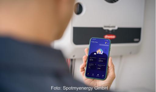 Eine Hand mit Handy, Spotmyenergy bindet Fronius-Wechselrichter in sein Heim-Energiemanagementsystem (HEMS) ein.