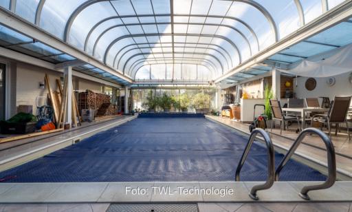 Im Bild das Außen-Schwimmbad, das im Winter überdacht ist und als saisonaler Wärmespeicher für die PVT-Kollektoren dient.
