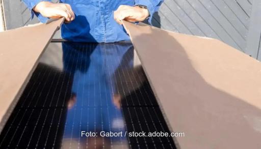 Ein Mensch öffnet einen Karton, in denen Solarmodule sind; Synapsun.com soll die Photovoltaik-Logistik verbessern.