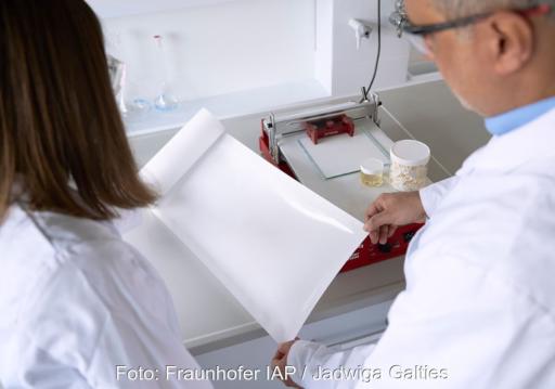 Forschende im Labor mit weißem Materialbogen zur Produktion von Separatoren für Batterien.