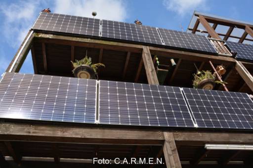 Photovoltaik an der Außenfassade von bayrischen Holzbalkonen.