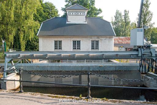 Kleines, historisches Wasserkraft mit Rechen im Vordergrund