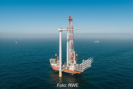 Installation einer Windenergieanlage mit Kranschiff auf dem Meer.