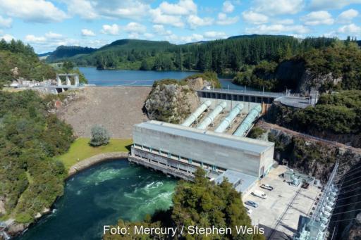 Das Foto zeigt ein Wasserkraftwerk in einer bewaldeten Hügellandschaft, dass einen Fluß in ein Oben und ein Unten teilt.