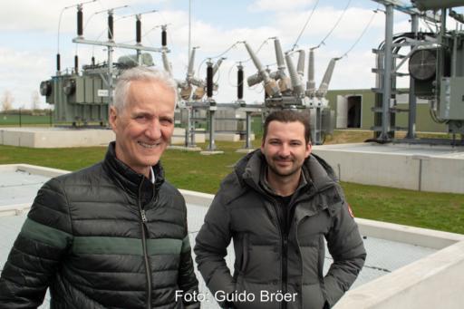 Mathias und Martin Niedzwetzki vor Trafos und großen Isolatoren im neuen Umspannwerk in Bartow.