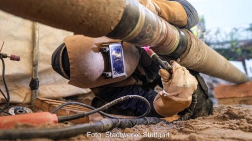 Ein Mann schweißt eine Stahlleitung, Stadtwerke Stuttgart bauen Wasserstoff-Pipeline für Green Hydrogen Hub.