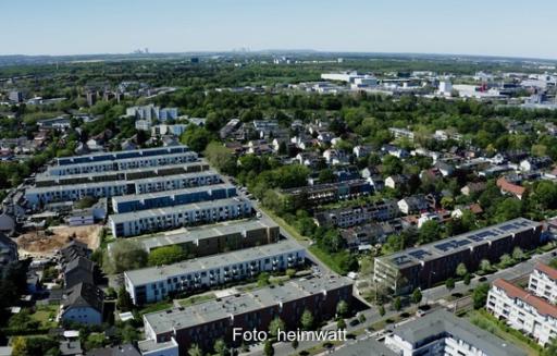 Das Foto zeigt Mehrfamilienhäuser und Gebäuderiegel aus der Luft von schräg oben.
