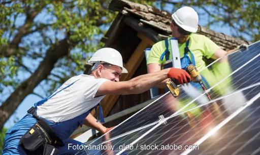 Zwei Männer montieren eine Solaranlage, die geplante Neuordnung der Netzentgelte gefährdet laut BSW-Solar den Ausbau der Photovoltaik.