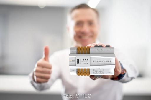 Person hält Smart-Meter-Gerät in der Hand mit Daumen hoch.
