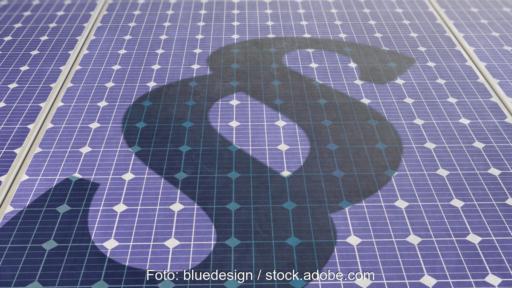 Photovoltaik-Module auf die ein Schatten in Form eines Paragraf-Zeichens fällt.