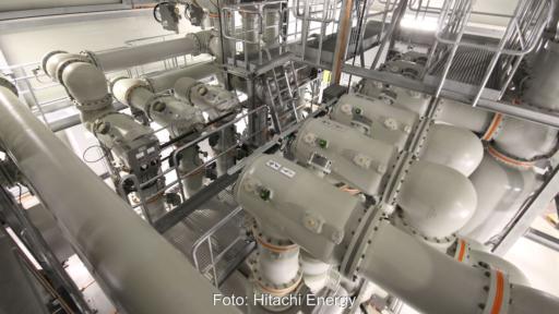 Blick in eine gasisolierte 420-kV-Schaltanlage mit großformatigen gekapselten Hochspannungskomponenten und Wartungsstegen.