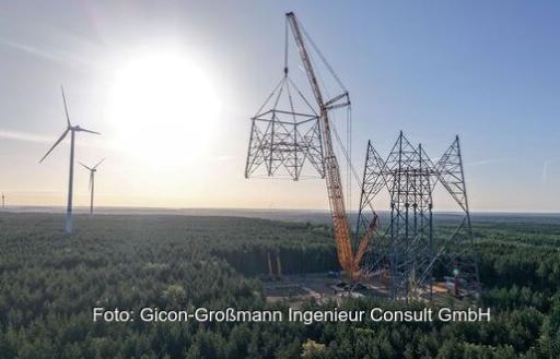 Ein Kran setzt eine Stahlkonstruktion auf einen Turm, die weltweit höchste Windenergieanlage entsteht in Brandenburg.