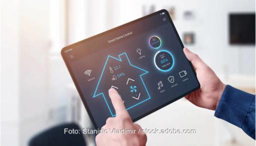 Hände halten ein Tablett mit Smart-Home-Steuerung, dynamische Stromtarife sind laut Verivox nicht günstiger als Festpreistarife.