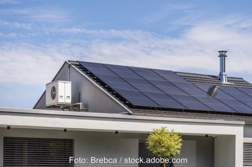 Hausdach mit PV-Anlage und am Giebel montierter Wärmepumpe.
