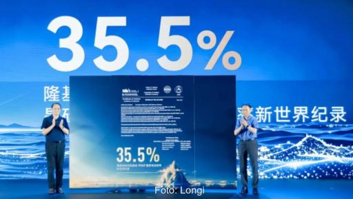 Offizielle auf einer Bühne mit dem Schriftzug 35,5 %, das ist der Wert für den Rekordwirkungsgrad für Tandemsolarzellen aus kristallinem Silizium und Perowskit.
