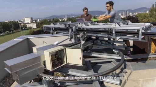 Zwei Forschende der TU Graz neben der faltbaren und nachgeführten, neuartigen Photovoltaik-Anlage.
