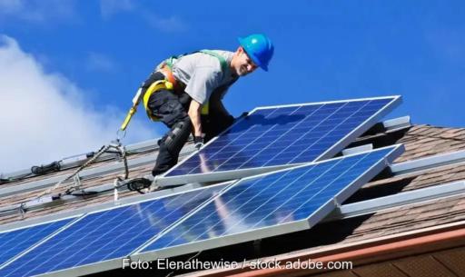 Monteur installiert PV-Anlage auf Schrägdach.
