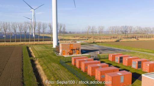 Batteriespeicherpark im Flachland mit benachbarter Windenergie und Photovoltaik.