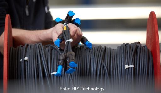 Hände halten einen werkseitig vorkonfektionierten Gleichstrom-Kabelbaum für die Photovoltaik-DC-Verkabelung.