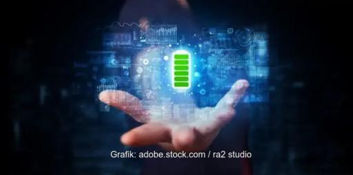 In einer bläulich gefärbten virtuellen Umgebung schwebt ein grün leuchtendes Batteriesymbol über einer geöffneten menschlichen Hand.