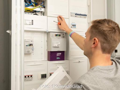 Person an einem Schaltschrank mit smart meter.