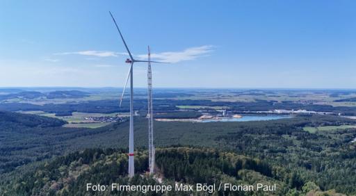 Ein Kran neben einer Windenergieanlage (WEA), Die höchste Serien-Windenergieanlage der Welt hat eine Weltrekord-Nabenhöhe von 199 Metern Max Bögl präsentiert sie auf der WindEnergy Hamburg 2026.