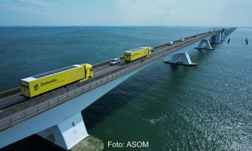 Zwei Lkw mit Solarmodulen auf eine langen Brücke über das Meer, fahrzeugintegrierte Photovoltaik könnte Europas Dieselimporte deutlich senken.
