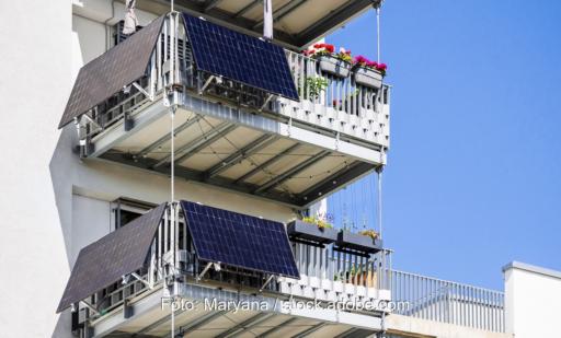 Balkonkraftwerke mit Solarmodulen und Wechselrichter, montiert an Balkonen eines Mehrfamilienhauses.