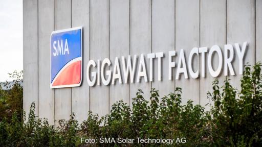 SMA Gigawatt Factory Niestetal im Anschnitt: graue Fertigungshalle für Großanlagen-Wechselrichter und Speicher mit Aufschrift Gigawatt Factory in weißen Großbuchstaben neben Firmenlogo.
