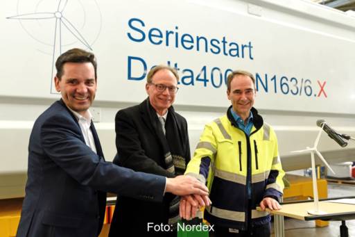 Drei Männer drücken symbolisch auf den Startknopf der Nordex-6 MW-Serienproduktion.