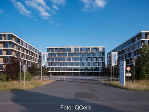 Mehrere moderne vierstöckige Bürogebäude unter blauem Himmel.